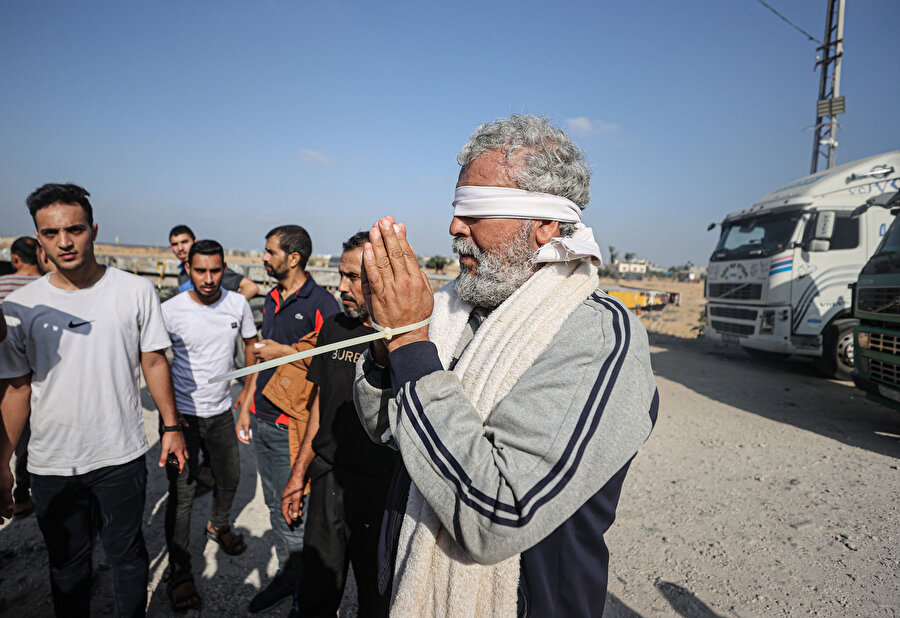 Bazı işçilerin ellerinin kelepçeli ve gözlerinin bağlı olması dikkat çekti.