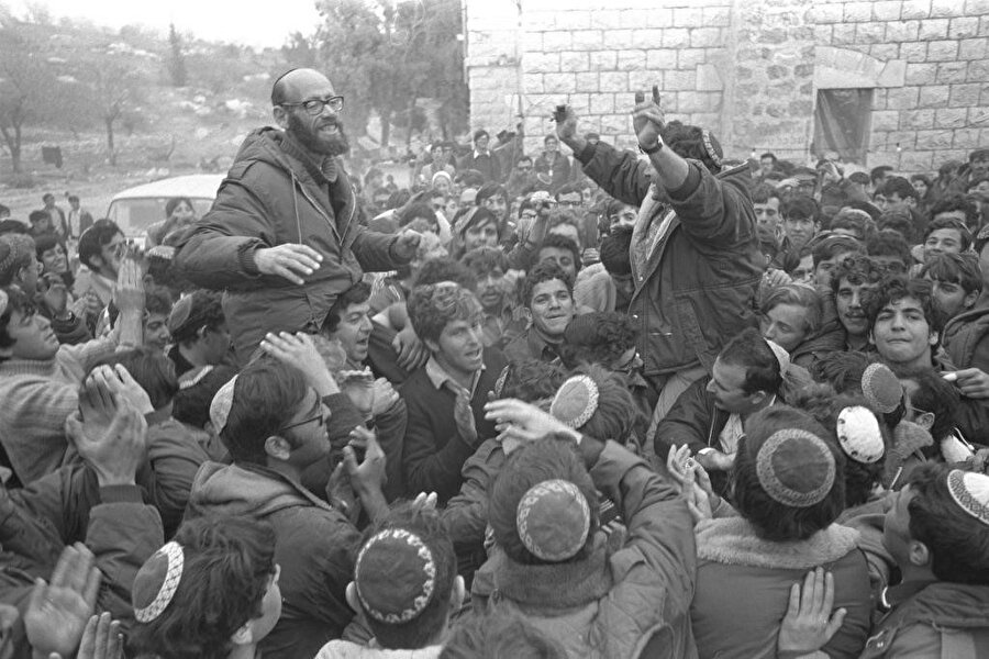 12 Nisan 1968'de, kendilerine “İsviçreli turist” süsü veren Siyonist Haham Moşe Levinger ve beraberindeki 60 kadar kişi, Filistin'in El Halîl şehrine zorla yerleşerek El Halîl’de kalıcı bir Yahudi yerleşimine giden yolu açmışlardı.