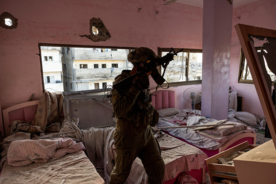 İsrail askeri Yarbay Ido, Gazze Şeridi'nin kuzeyinde, bir konutun içinde silah üretimi için kullanılan bir atölyenin üzerinde yer aldığını iddia ettiği ve bombaladıkları bir yatak odasında, 8 Kasım 2023.