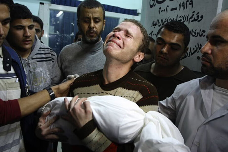 İsrail saldırılarında henüz yaşını doldurmamış çocuğunu yitiren BBC Arapça muhabiri Cihad Mişravi, Gazze'deki Şifa Hastanesi'nde oğluna son kez sarılıyor.
