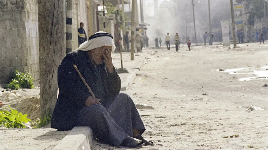 İsrail askerlerinin attığı göz yaşartıcı bombadan etkilenen bir Filistinli.