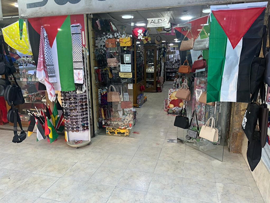 Ürdün'de Filistin bayrakları ve kefiyeler asılmış bir dükkânın girişi.