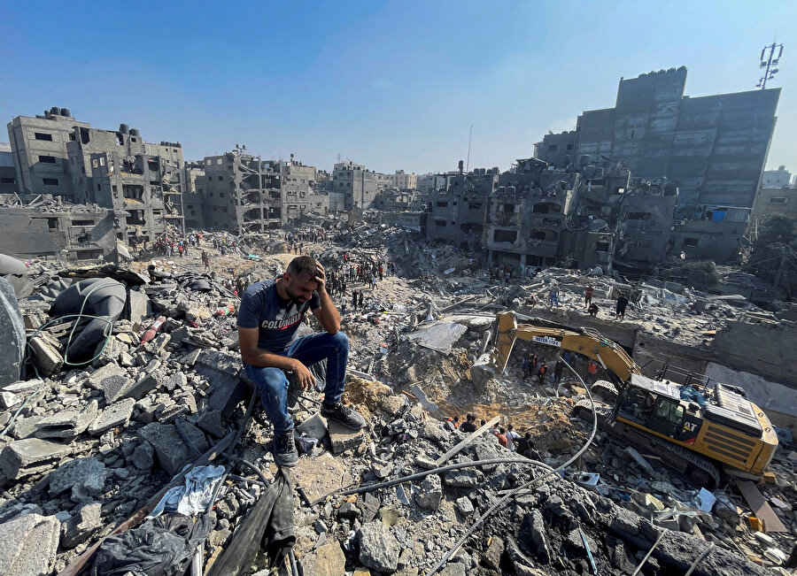 Gazze'de İsrail'in vurduğu binaların enkazında arama kurtarma çalışmaları yapanlar ve aynı enkazda yakınlarını kaybedenler...