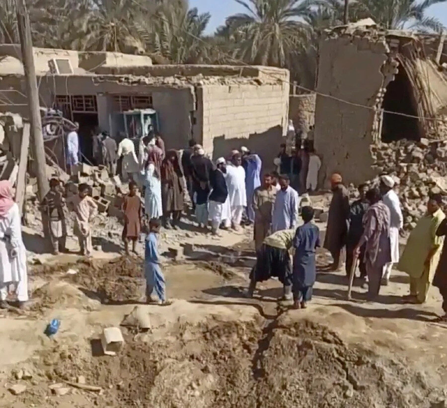 Pakistan'ın İran'ın Sistan ve Belucistan eyaleti, Saravan yakınlarındaki bir köye düzenlediği askerî saldırının ardından insanlar molozların yakınında toplandı, 18 Ocak 2024.