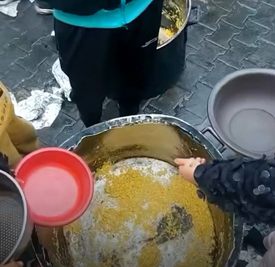 Açlıkla mücadele eden Gazzeliler, kazanlarda yapılan pilavların en son tanesini dahi almaya çalışıyor. Yemek sırasında bekleyen çocuklar biraz daha fazla yemek alabilmek için görevlilere yalvarıyor.