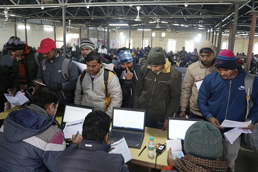 İsrail'de işe alınmak isteyen Hintli işçiler, Hindistan'ın Lucknow kentinde düzenlenen bir işe alım kampanyası sırasında formlarını sunuyorlar.