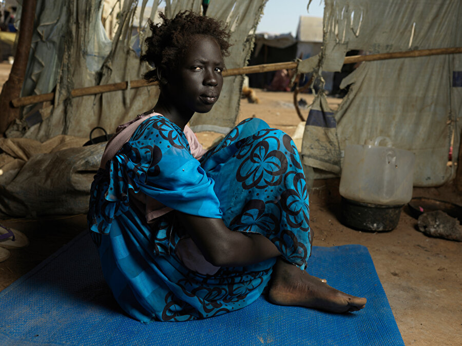 13 yaşındaki Nyasebit, annesini Sudan savaşında kaybetti. Hane reisi olarak iki erkek kardeşini yedi gün boyunca yürüyerek Renk’e götürdü. Çocuklar, teyzeleriyle birleştirildikleri Plan International barınağında kalıyorlar. 
