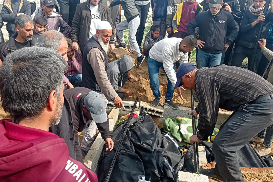 Ebu Cevad, mezarlıkta çalışan gönüllü arkadaşlarıyla birlikte bir başka defin görevini yerine getirirken.
