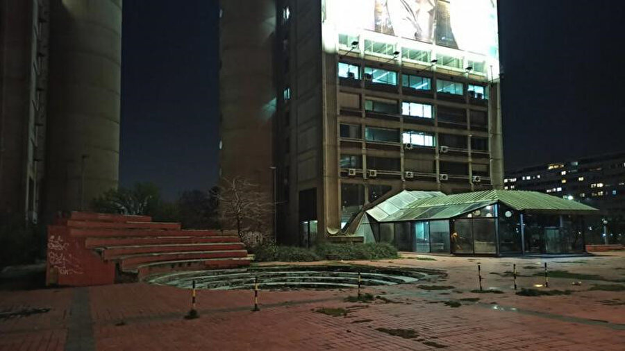 Yapı önündeki tekinsiz meydan ve peyzaj alanları, terk edilmiş dükkanlar. Fotoğraf: Darmon Richter 