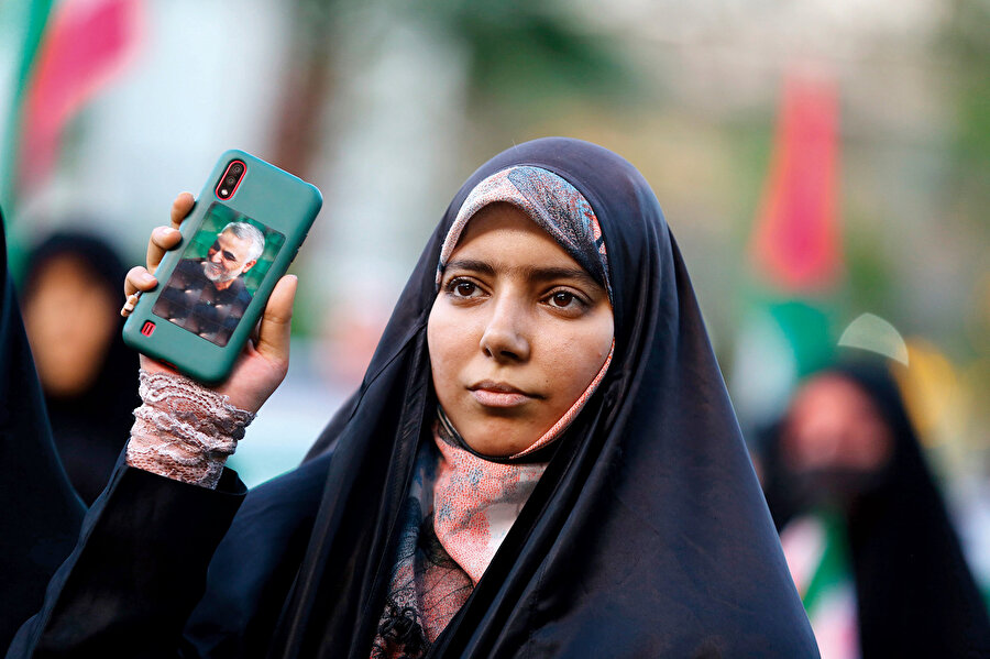 Kasım Süleymani fotoğrafını telefonuna yapıştıran İran’lı bir kadın.