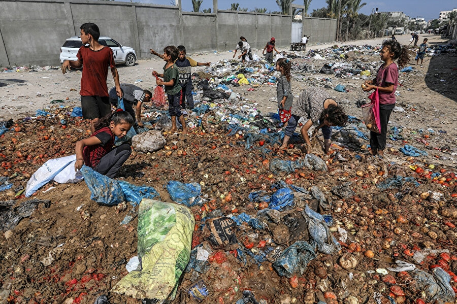 Deyr Balah kentinde çaresiz kalan Filistinli çocuklar, çöplerin arasında yiyecek arıyor.