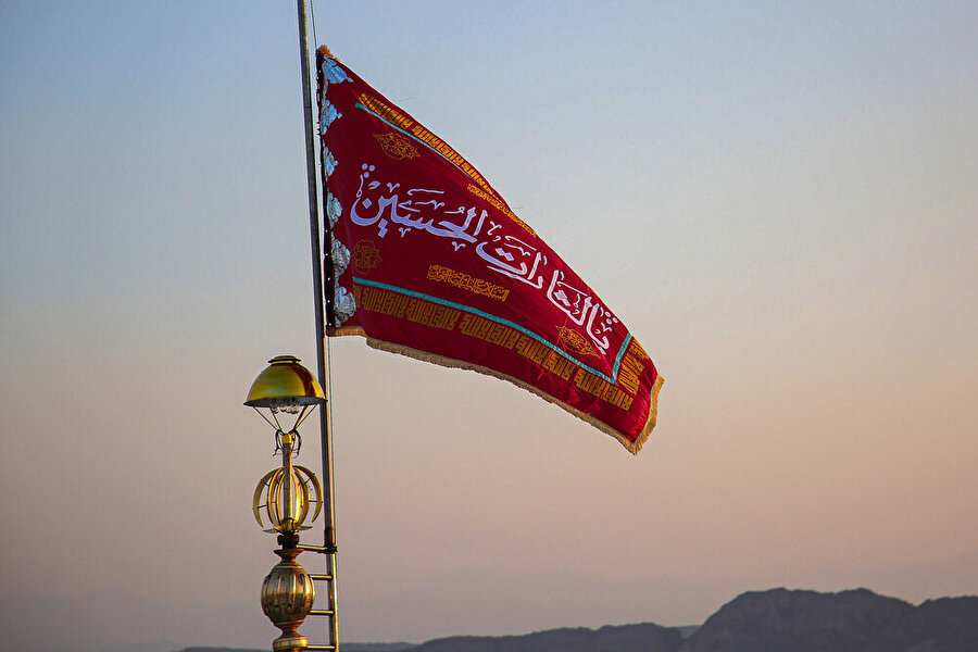 Cemkeran Camii'ne çekilen kırmızı renkli bayrağın üzerinde “Ya el-saratel Huseyn” yani “Ey Hüseyin’in intikamı” yazıyor.