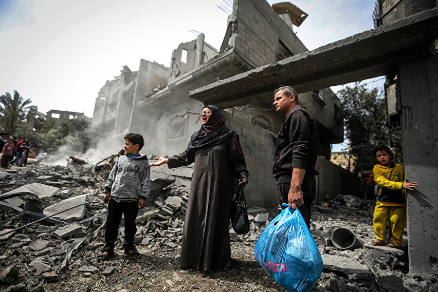 İsrail hava saldırısının ardından Gazze'nin merkezindeki Megazi Mülteci Kampı’nda enkazdan eşyalarını toplayan Filistinliler, 29 Mart 2024.