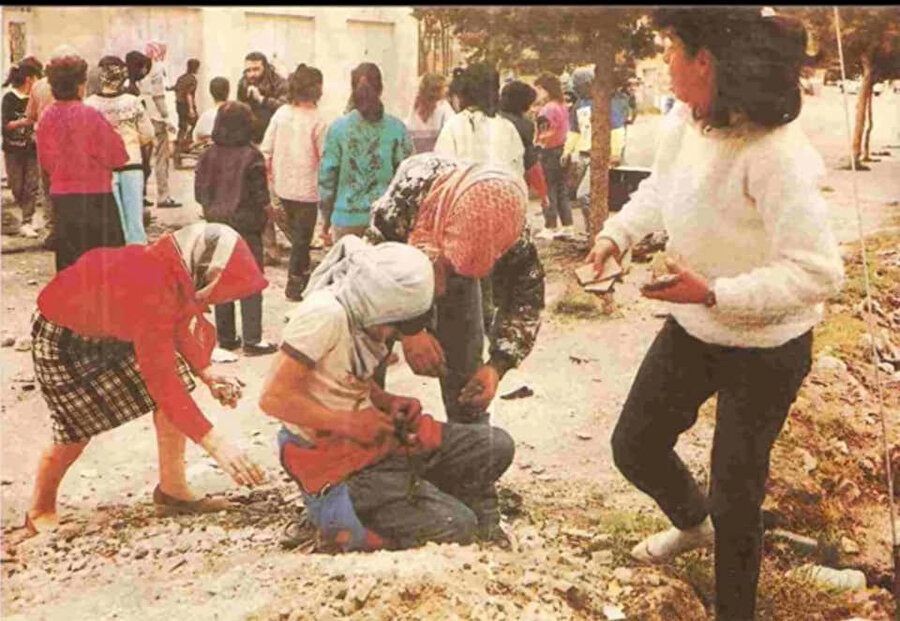 İsrail askerleri atmak üzere yerden taş toplayan Filistinliler.
