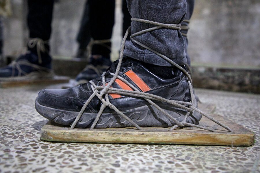 İşçiler sabun levhalarının çökmesini önlemek için ayaklarına tahta levhalar bağlıyor.