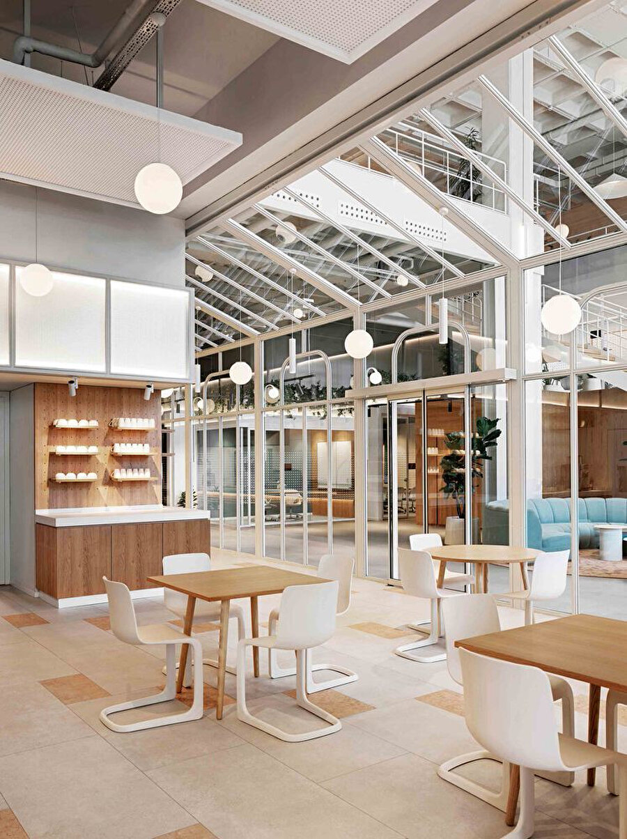 Victoria dönemi cam serasından ilham alan kafeterya bölümü, küresel aydınlatmalar ve beyaz-ahşap mobilyalarla şekilleniyor. 