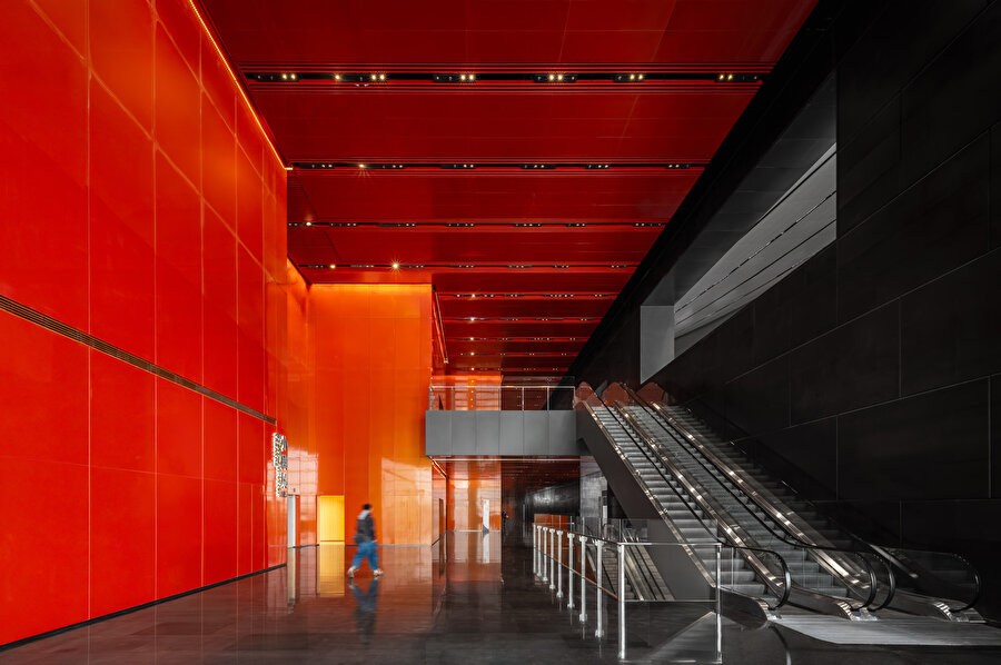 Beijing Performans Sanatları Merkezi'nin giriş holü, canlı kırmızı duvarlar ve siyah zeminle dramatik bir kontrast oluştururken ziyaretçilere etkileyici ve işlevsel bir karşılama alanı sunuyor.