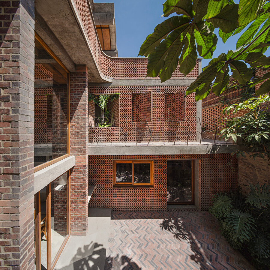 Tropikal bitki örtüsüyle çevrili olan yapı, hem manzarayı evin bir parçası haline getiriyor hem de yapı sakinleri için mahremiyet sağlıyor. 