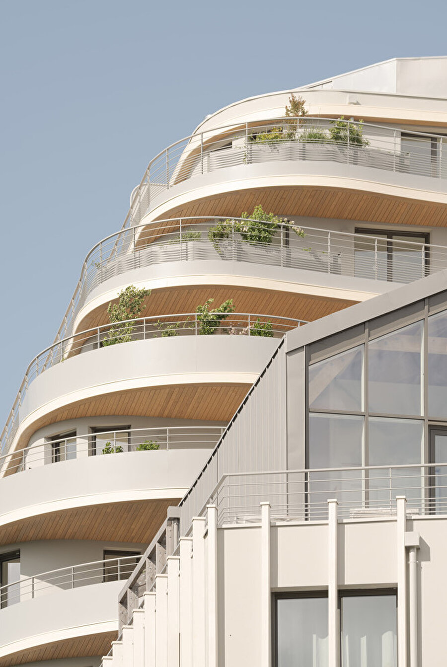 Binayı saran merdiven ve korkuluk detayları yapıya endüstriyel bir karakter katarken alt katlardaki cam yüzeyler şeffaf bir geçiş alanı tanımlıyor.