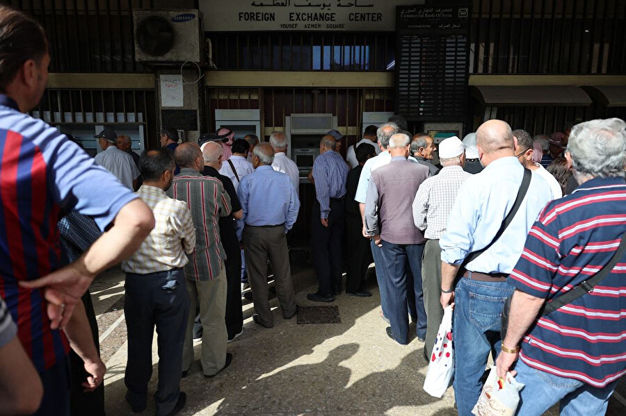 Yerel para biriminin değerinin dolara karşı yaklaşık 8.500 dolara yükselmesinin ardından, bankaların önünde halkın ellerindeki dolarları Suriye lirasıyla değiştirmek için kuyruklar oluştu.