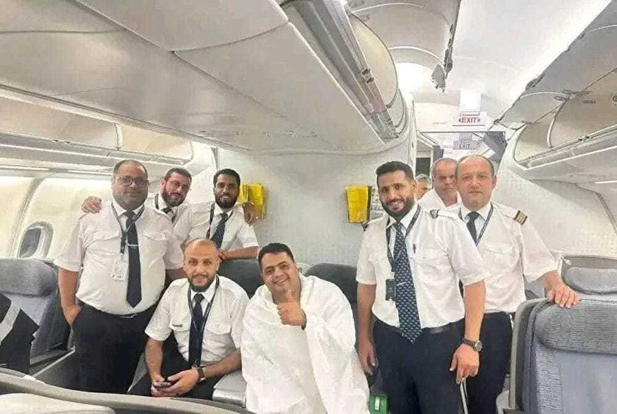 Libya'dan Mekke'ye giden uçağı pistten iki kez geri dönüp ancak üçüncü kalkışta binebilen Amir, ihramını bürünmüş bir şeklide kutsal topraklarda uçuş ekibiyle böyle poz verdi.