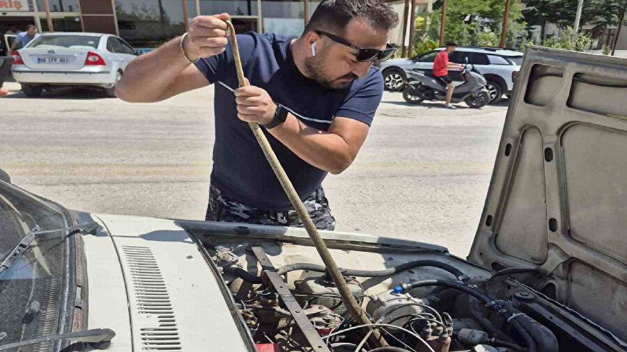 Araç motorundaki yılanı çıkaran vatandaş