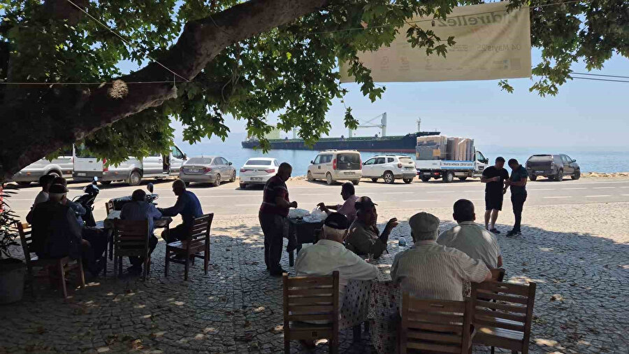 Köy kahvehanesinde vatandaşlar gemiyi seyrediyor