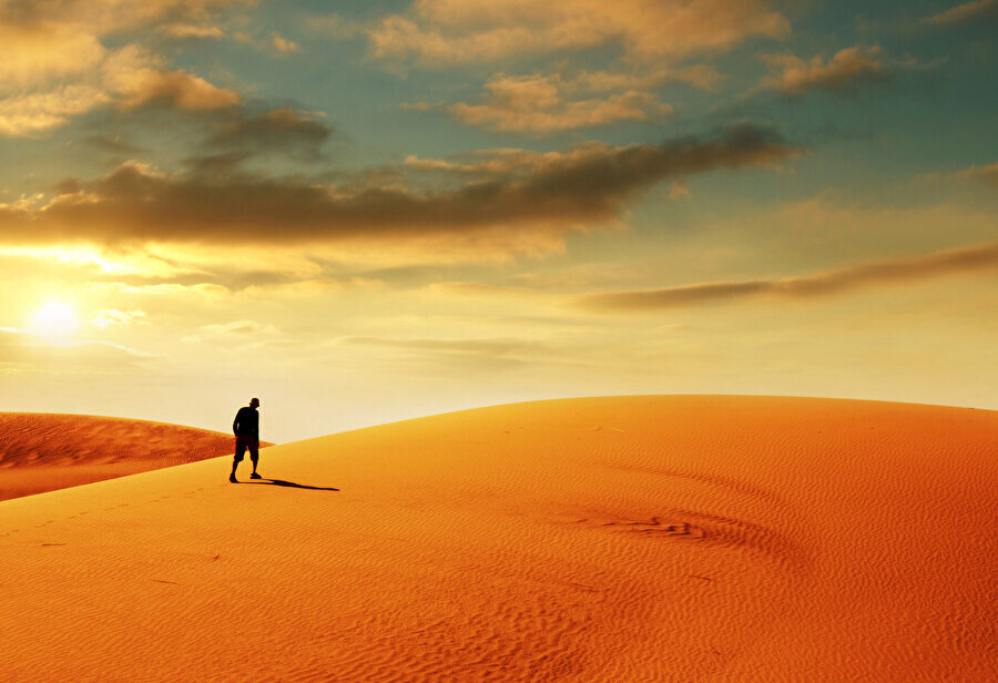 Tepeye ulaştığımda hem rüzgârdan, hem yorgunluktan yüzüm neredeyse yarısı çöl ufkunda kaybolan güneş gibi kıpkırmızı kesilmiş.