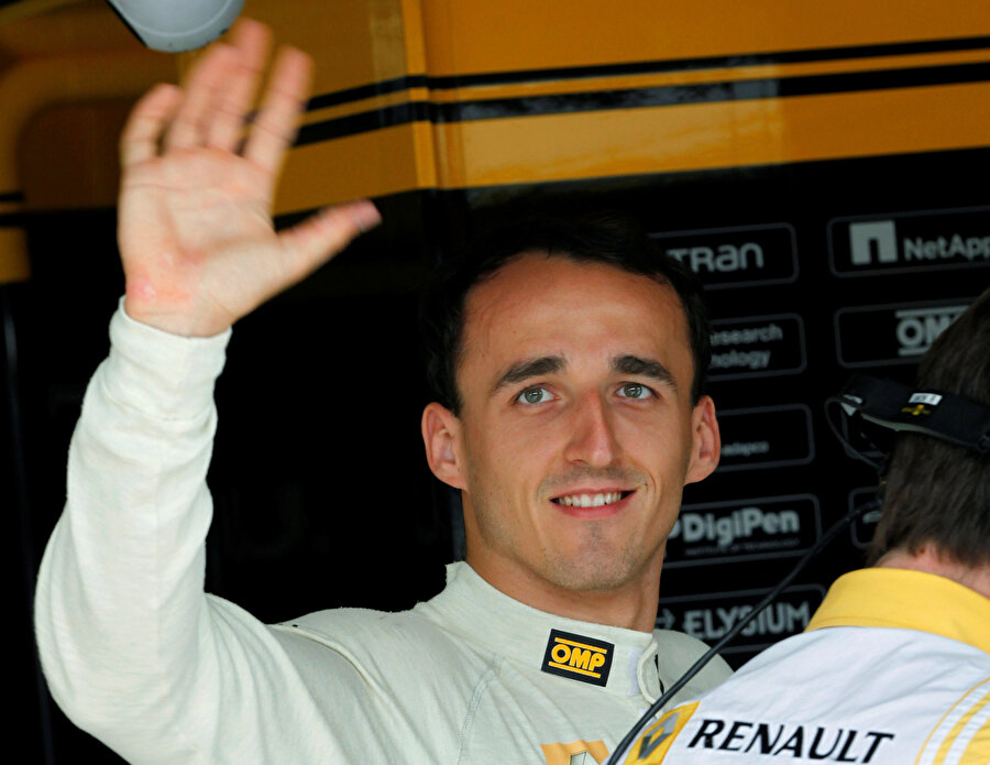 Robert Kubica fotoğraflarını çeken basın mensuplarına selam veriyor.