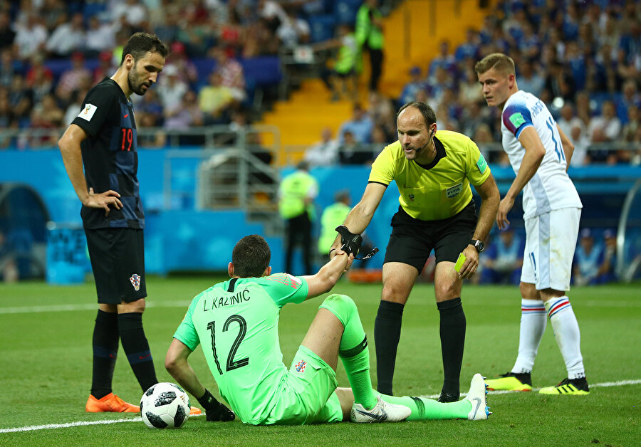 Antonio Mateu Lahoz, kaleciyi yerden kaldırıyor.