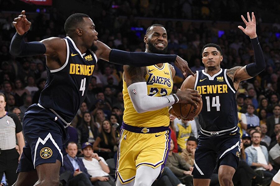 LeBron James rakibinin müdahalesine rağmen pozisyonu bitirmeye çalışırken.