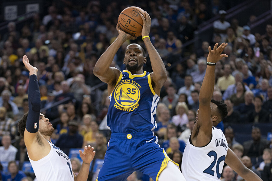 Kevin Durant, iki rakibinin arasından şut atarken.