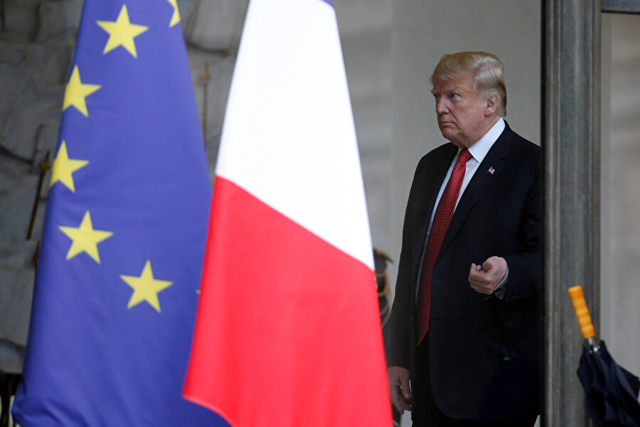 ABD Başkanı Donald Trump, AB ve ABD bayraklarının arkasında görünüyor.