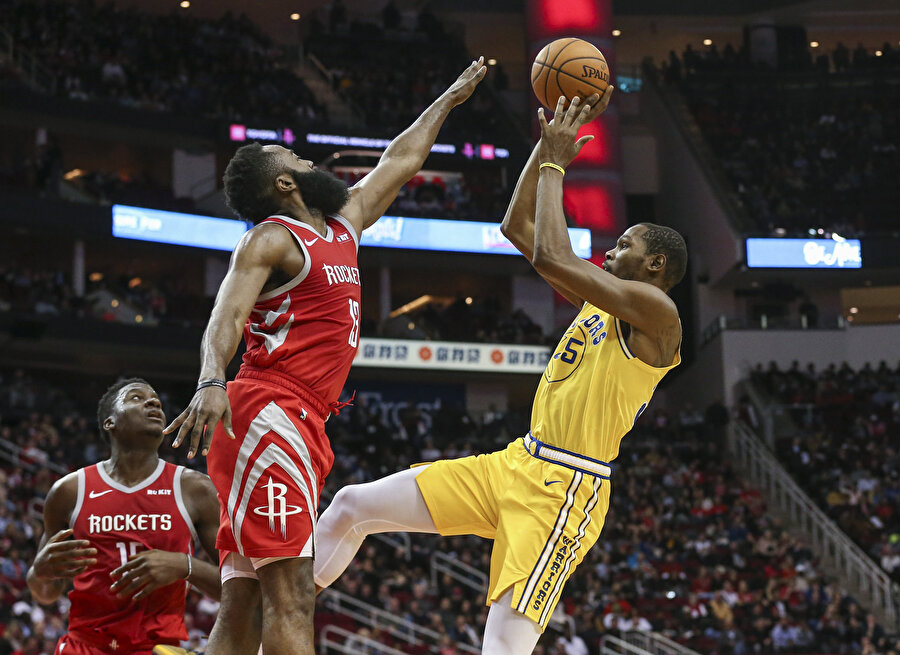 Kevin Durant, James Harden'ın savunmasına rağmen şut atarken.
