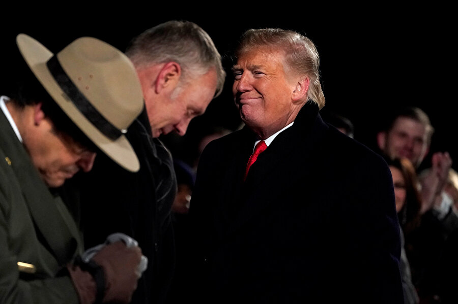 Donald Trump, kendisini alkışlayan kalabalığa gülümsüyor.