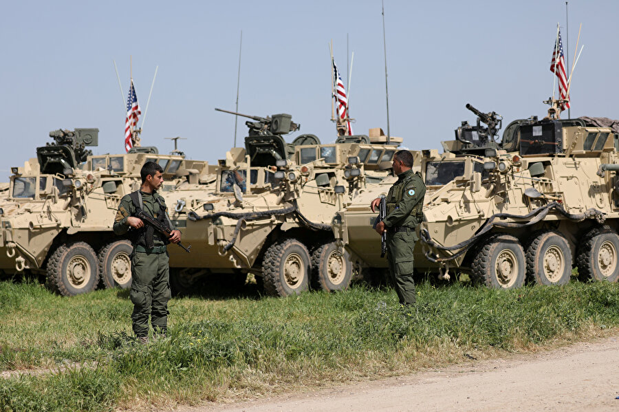 YPG'li teröristler, Amerikan bayrağı taşıyan askeri araçların önünde nöbet tutuyor.