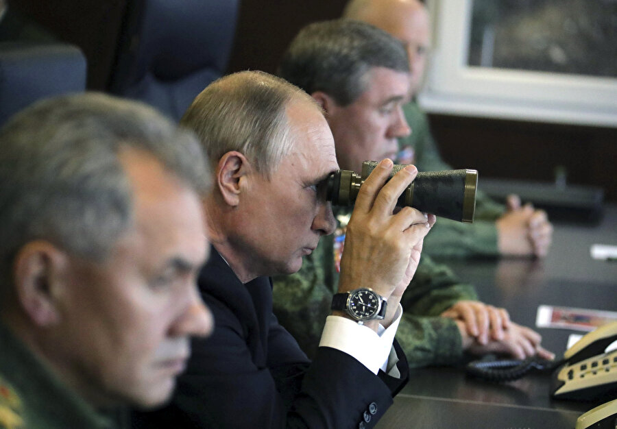 Rusya Devlet Başkanı Vladimir Putin dürbün kullanırken görünüyor.