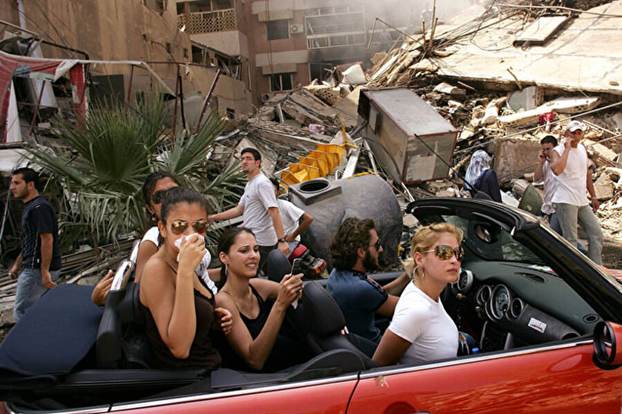 2006 Spencer Platt
Beyrut'ta İsrail tarafından bombalanmış bir sokağı, ilk ateşkesin ardından, üstü açık bir otomobilde pahalı giysiler içinde gezen gençler karmaşa ve savaşı görüyorlar...