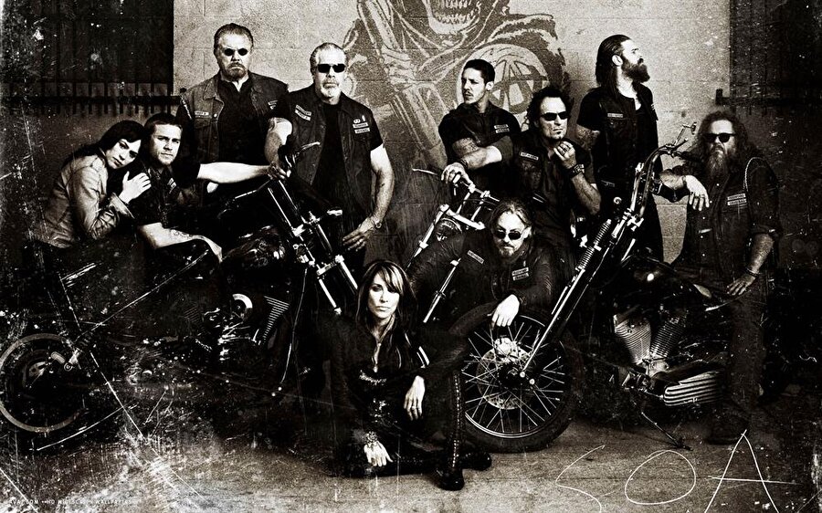 Sons Of Anarchy

                                    
                                    
                                    
                                    
                                    Onlar düzen dışı asiler, kendi kurallarından başkasını tanımıyorlar ve altlarındaki çeliklerle çok çekiciler! Burası Anarşistlerin Motosiklet Kulübü!  Jackson 'Jax' Teller (Charlie Hunnam), anne Gemma Teller Morrow (Katey Sagal) ve Jackson'ın üvey babası ve de çetenin başı Clarence 'Clay' Morrow (Ron Perlman) doğup, büyüdükleri California, Charming kasabasını kendi yöntemlerine göre korumaya kararlı bir ailedir. Onların çevresinde şekillenen motosikletli çete, kasabaya başka çetelerin dadanmasına engel olarak ve kanun dışı yürütülmesi gereken ne iş varsa üstleniyor!  Çete başı Clay işleri kendi usulleriyle ve şiddetle çözmeyi tercih ederken, üvey oğlan Jax ise ölen babasının günlüğünü rehber alarak, eski yöntemlerin değişimini savunur. İki kuşak arasındaki bu çatışma SAMCRO'yu ve çete üyelerinin aralarındaki ilişkileri de ciddi biçimde etkiliyor...
                                
                                
                                
                                
                                