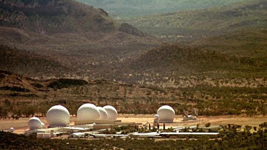Avustralya'daki Pine Gap
Pine Gap Avusturalya'nın ortasında olmasına rağmen ABD hükümeti tarafından yönetilen bir uydu takip istasyonudur. İçeri girilmesini bırakın üzerinden uçmak bile yasaktır.1970 yılında inşa edilen bu tesis ile ilgili olarak Avusturya çok fazla açıklamak yapmaktan kaçınırken, orasının bir uydu takip merkezi olduğu dile getirilmektedir.Tesis ile ilgili olarak pek çok komple teorisi üretilmektedir. ABD hükümetinin insansız hava araçlarını buradan yönettiği iddia edilmektedir. Sır dolusu tesise girmek ve üzerinden uçmak kesinlikle yasaktır.