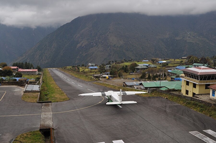 Lukla Havalanı – Himalaya
Bir yanında dağ olan havaalanı Nepal'in Lukla kasabasında bulunan küçük bir havaalanıdır. 2900 metre yükseklikteki bu havaalanı, everest dağına tırmanış yapmaya gelen dağcıların ilk geldikleri yerdir. 

 Değişken hava koşulları, etrafının dağlarla çevrili olması ve pistin kısa oluşu sebebiyle dünyanın en tehlikeli havaalanıdır. Pistin bir tarafı dağ iken diğer tarafı uçurumdur. En ufak bir hava değişikliği uçuşları engeller. 

 Ve havalimanı bir köyün içerisindedir. Uçaklar uçuş noktasına gitmek ya da piste çıkmak için köyün sokaklarında gezmektedir. 

