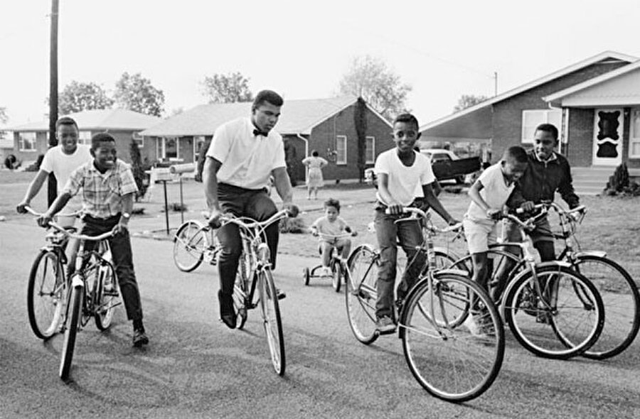 Bisikleti çalındı

                                    
                                    
                                    
                                    Muhammed Ali'nin boksla tanışması ise son derece trajikomik… 1954 yılında babasının aldığı Schwinn marka bisikletiyle panayıra giden küçük Muhammed Ali, üzücü bir sürprizle karşılaştı. Irkçılığın hat safhada olduğu o yıllarda, Muhammed Ali'nin bisikleti çalındı. Panayırda boks maçı izleyen bir polisten yardım isteyen ancak umduğu yanıtla karşılaşamayan Muhammed Ali, yaşadığı üzüntünün ardından 'Bisikletimi çalanları bir boksör gibi yere sereceğim” yeminini etti.
                                
                                
                                
                                