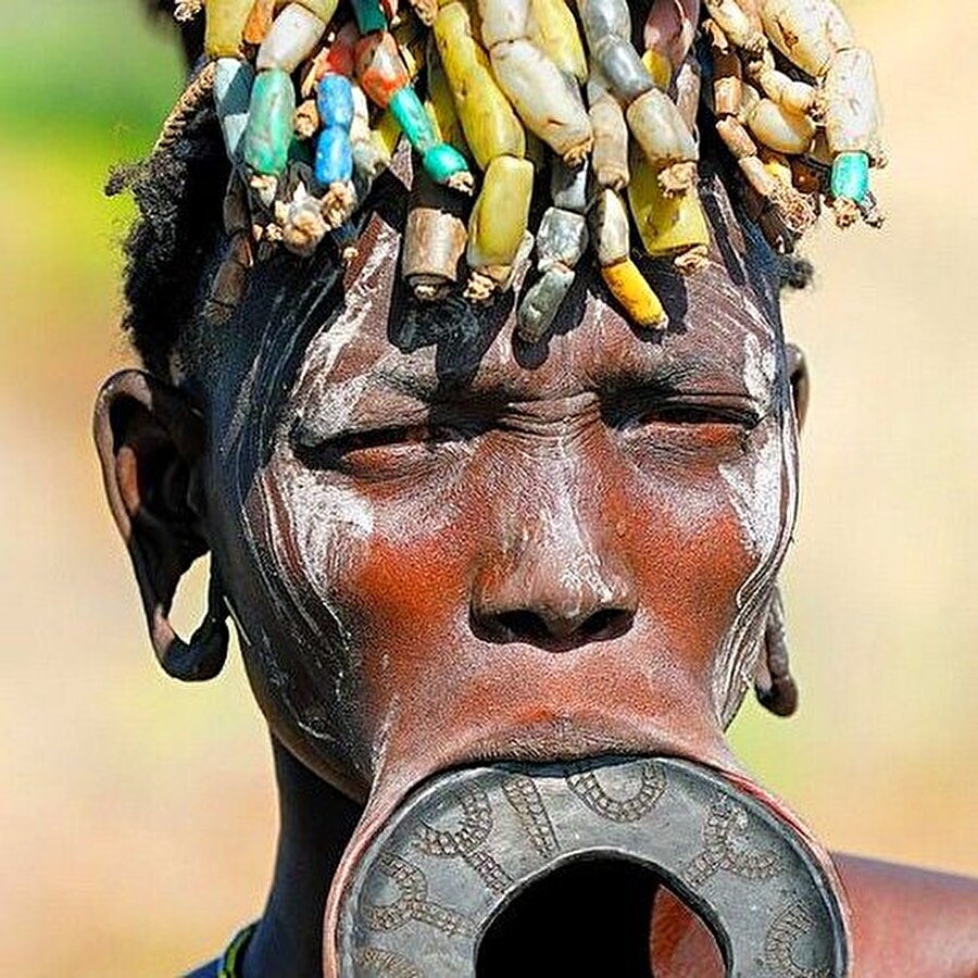 Güzellik sembolü halka
Afrika'da ağız ve buruna takılan halka güzellik sembolü. Özellikle dudağa takılan halkanın büyüklüğü, yaş ilerledikçe 25 cm'e kadar uzanıyor. En büyük halkayı takan kadın, en güzel ve saygı duyulan anlamı taşıyor.