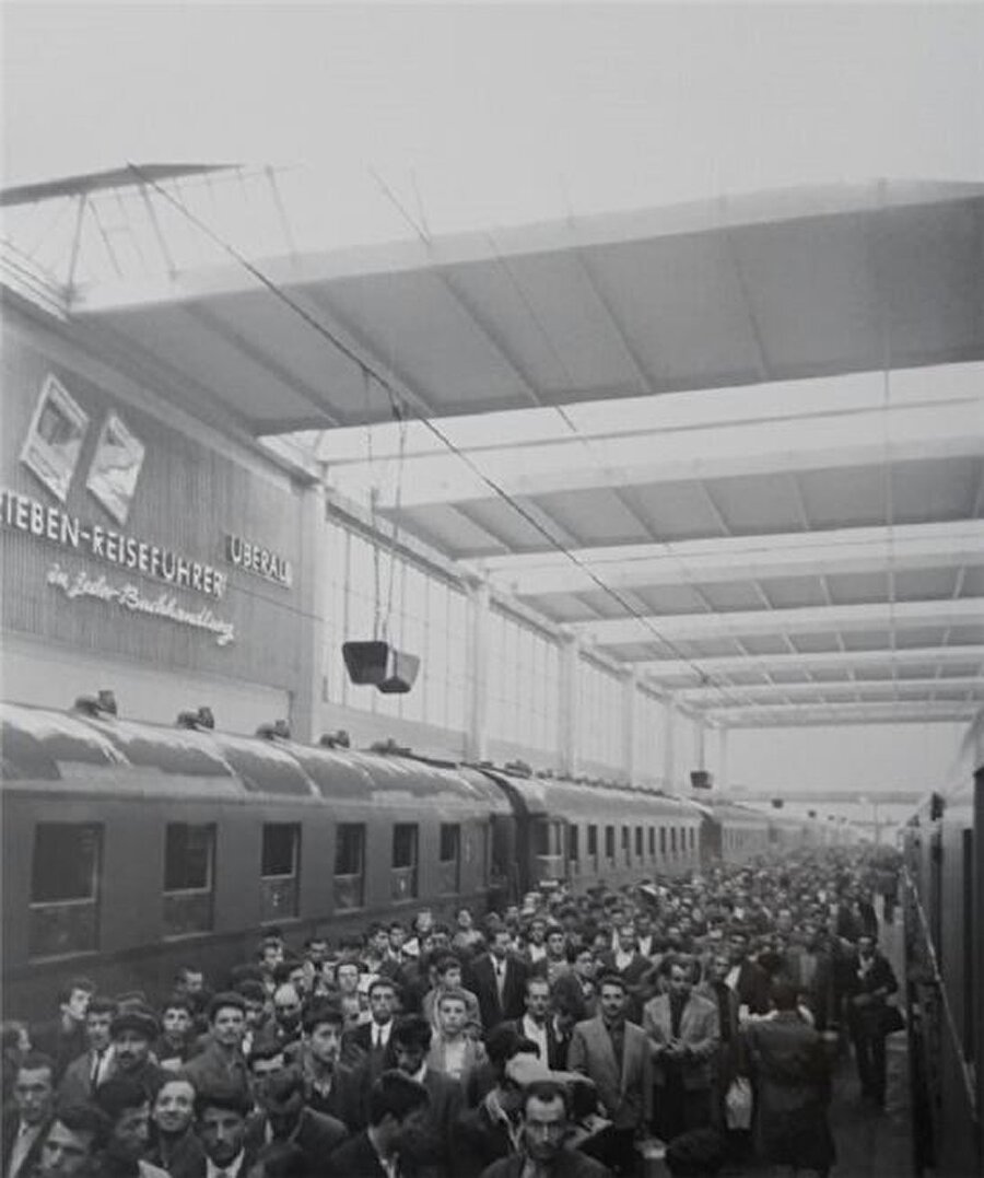 1964 Münih Almanya
Umut yüklü trenler

Türkler için Münih Tren Garı, sadece bir gar değildir.

İlk giden Türk işçileri için burası, dışlanmadıkları, ötekileştirilmedikleri, kendilerini "yabancı" hissetmedikleri bir yer olmuştur. Burası, "gastarbeiter"lerin yani misafir işçilerin buluşup dertleştikleri, memleket hasreti giderdikleri, sılaya dönme umutlarını sürekli yeşerttikleri Almanya'nın en bilindik köşesidir. Kader arkadaşlarının "acı vatan"ın dört bir yanına dağıtıldıkları, Almanya'daki ilk ayrılma noktalarıdır. İlk ayrılma noktası ise, "gurbetçi"ler için en kolay, en ideal buluşma noktasıdır.

(Yusuf Adıgüzel)