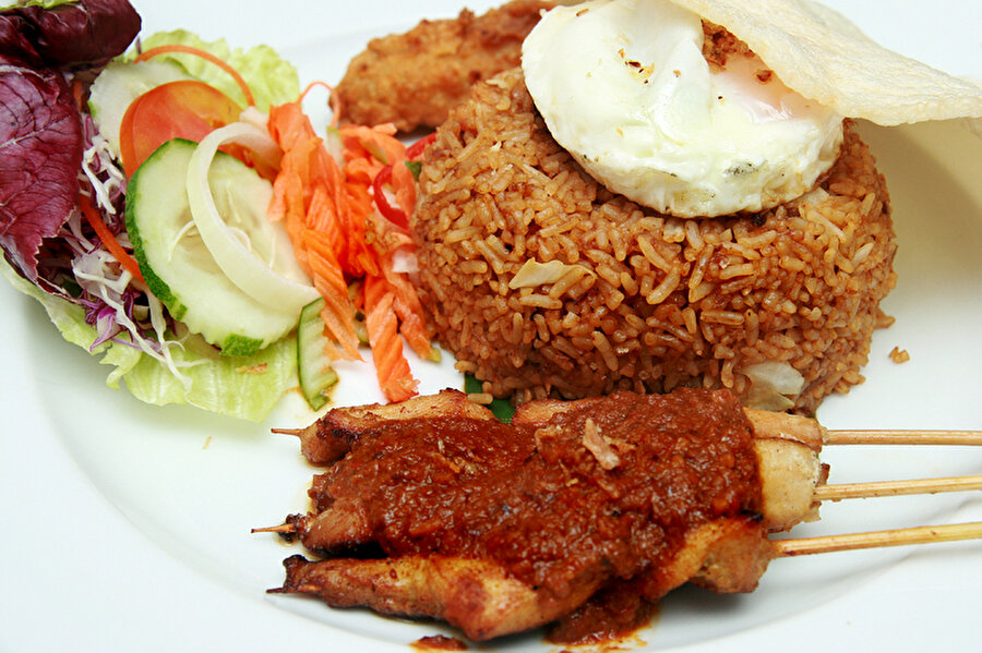 Endonezya'da Nasi Goreng 

                                    
                                    
                                    
                                    
                                    
                                    
                                    
                                    "Kızarmış pirinç" anlamına gelen bu yemek metal kaplarda Endonezya sokaklarının her köşesinde satılıyor. Nasi Goreng 2011 yılında "Dünyanın en lezzetli 50 yiyeceği" listesinde ikinci sırada yer alıyor. İçeriğinde haşlanmış soğan, sarımsak, pirinç sosu, acı domates olan kızarmış pirinç, tavuk, yumurta, ıstakozlarla servise sunulur. 





 

                                
                                
                                
                                
                                
                                
                                
                                