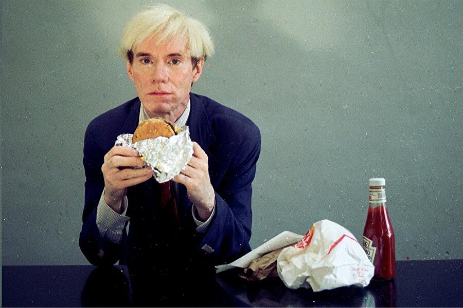 Hamburger
Warhol, video art'larla da tüketim nesnesi ve sanat arasındaki mesafeyi "hamburger yeme" üzerinden gösteriyordu. Sanat, herkes için olmalıydı.