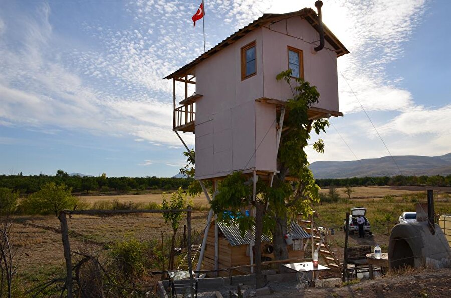 Bahçede daha önce çıkan bir yangında zarar gören ceviz ağacının 5,5 metre yükseğine iki katlı bağ evi inşa eden Seheryıldızı, beslediği hayvanlarını bırakmamak için elektrik ve suyu olmayan evde 2 yıldır yaşamını sürdürüyor.