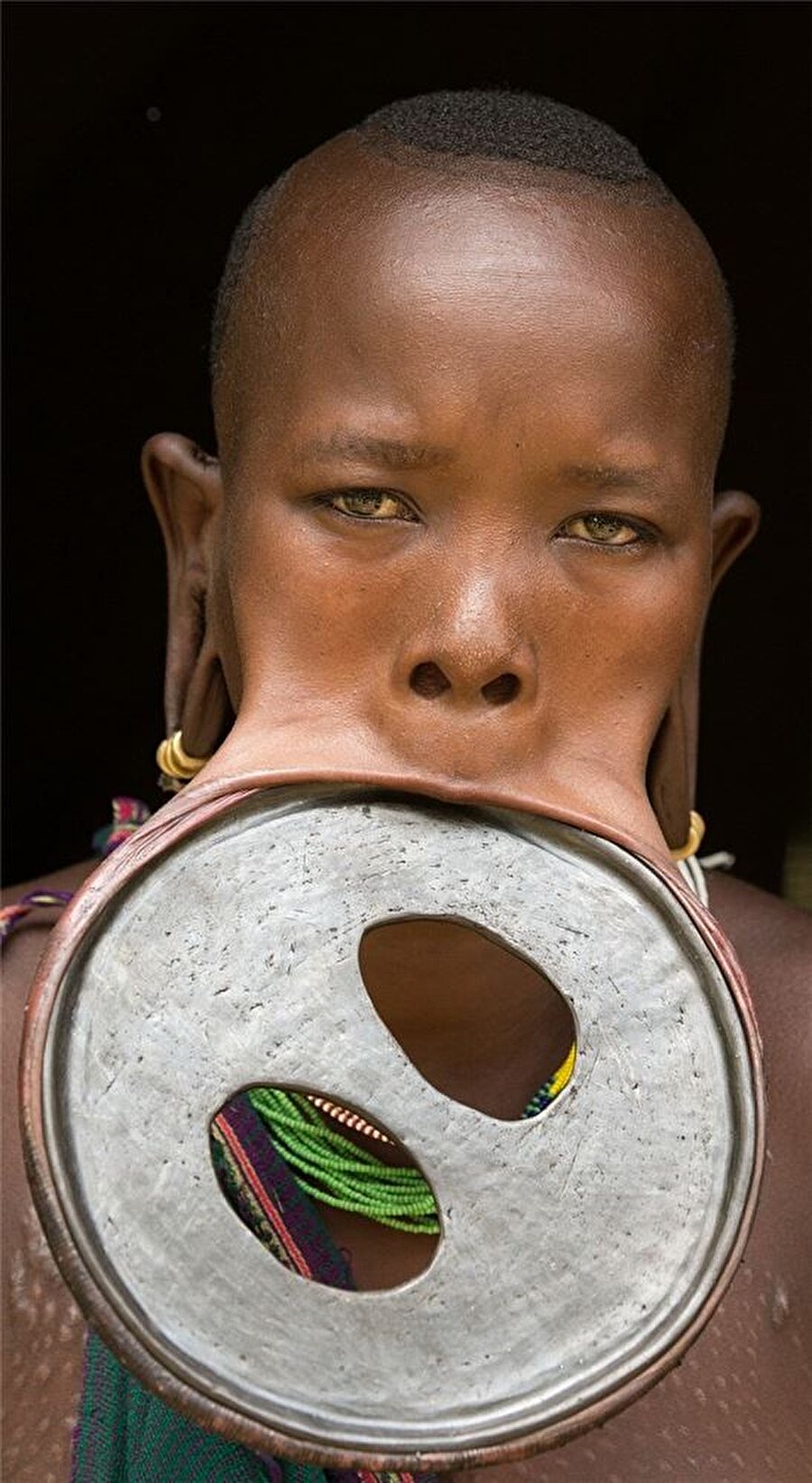 Ahşap disk
Güney Afrika'da çoğunlukla Mursi, Surma ve Sara kabilelerinde uygulanan dudağa ahşap disk yerleştirme, daha çok 15-16 yaşına gelen kızlarda görülüyor. Anneleri tarafından dudakları kesilen kızlar anlamı pek bilinmeyen ahşap disklerle ağızlarını büyütüyor. 

Kimileri güzellik amacıyla taktığını söylerken kimileri "Başlık parası fazla olan kadının dudağındaki disk büyük olur" diyor. Ahşap disklerin ayrıca köle ticaretini engellemek amacıyla uygulandığı düşünülüyor.