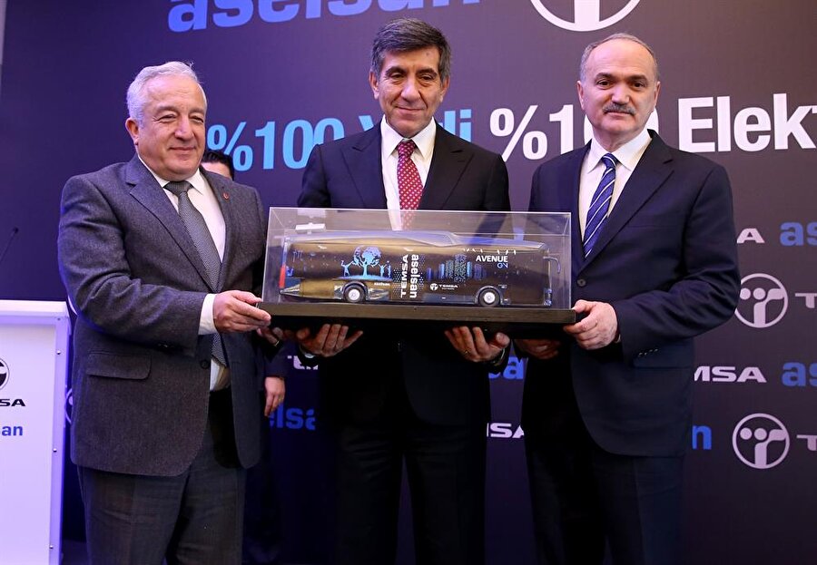 Konuşmasının ardından Bakan Özlü'ye, Sabancı Holding Üst Yöneticisi (CEO) Zafer Kurtul ve Türk Silahlı Kuvvetleri Güçlendirme Vakfı Müdürü Orhan Akbaş tarafından otobüs maketi takdim edildi
