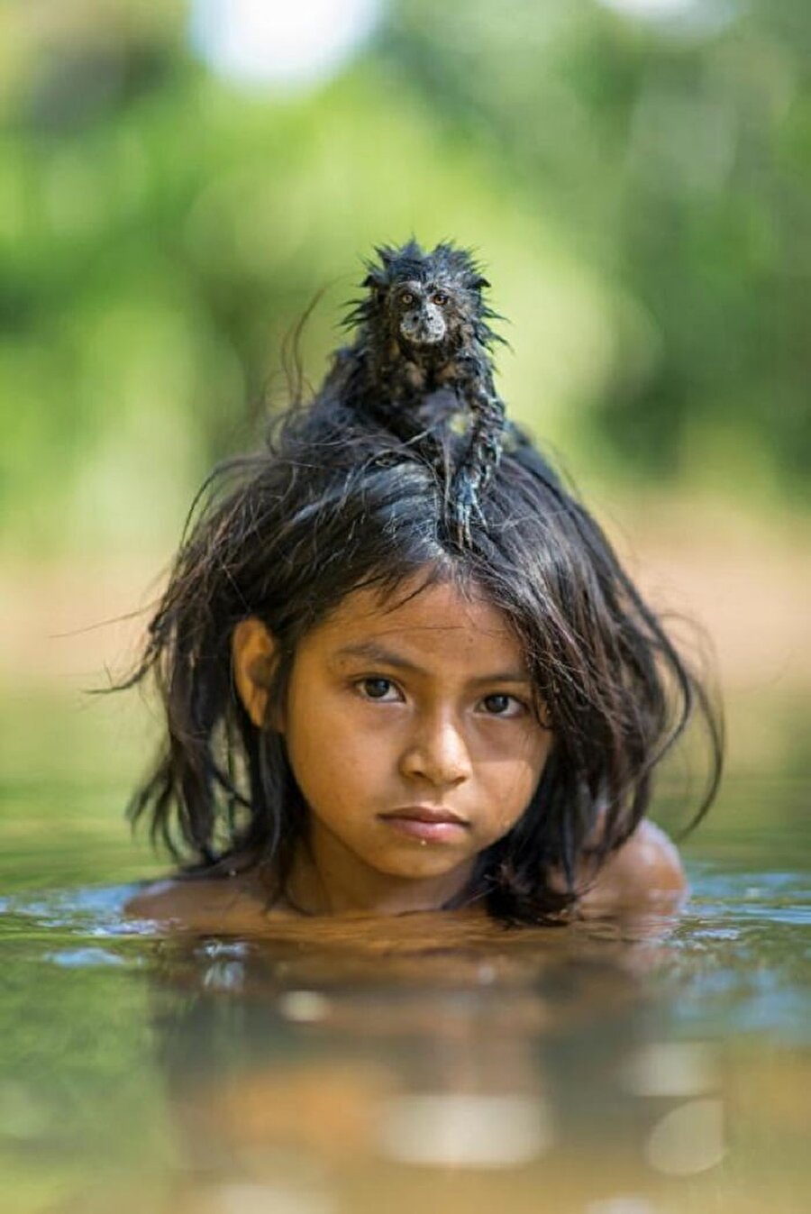 Peru /Yomibato River
Küçük bir çocuk, hayvanlarla birlikte nehirde yüzüyor. 